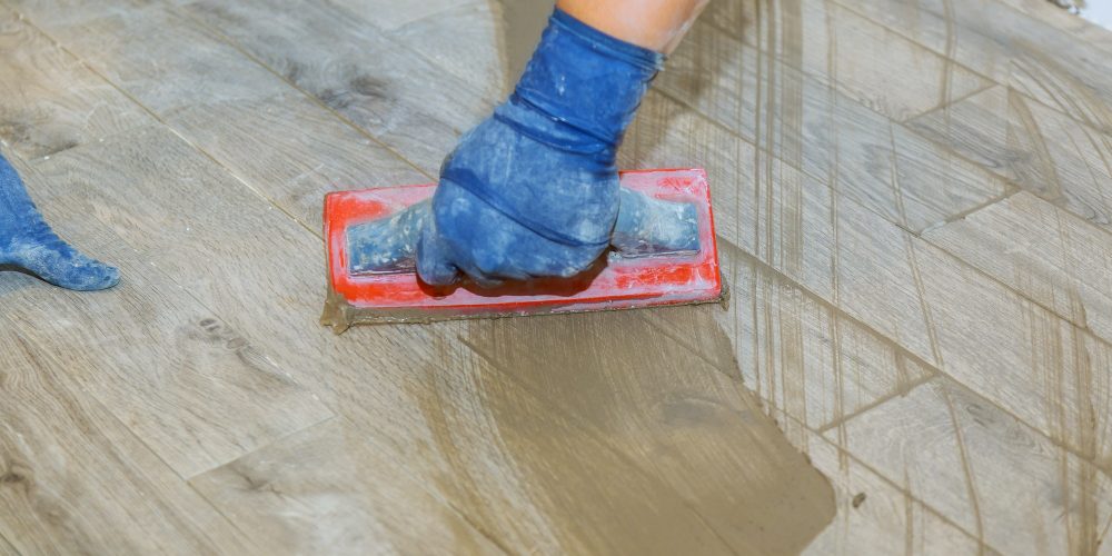 hand-of-flooring-on-gray-color-of-new-grout-tile-o-E24E3NG (1)